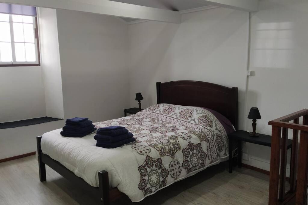 una camera da letto con un letto con due asciugamani blu sopra di Casa dos Fenais a Praia da Graciosa