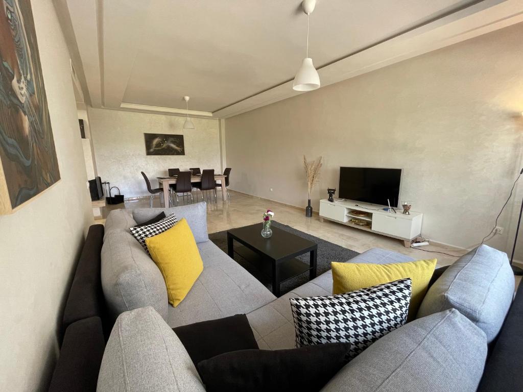 a living room with a gray couch and yellow pillows at Chic & cosy Flat Near Airport lockbox fast wifi in Nouaceur