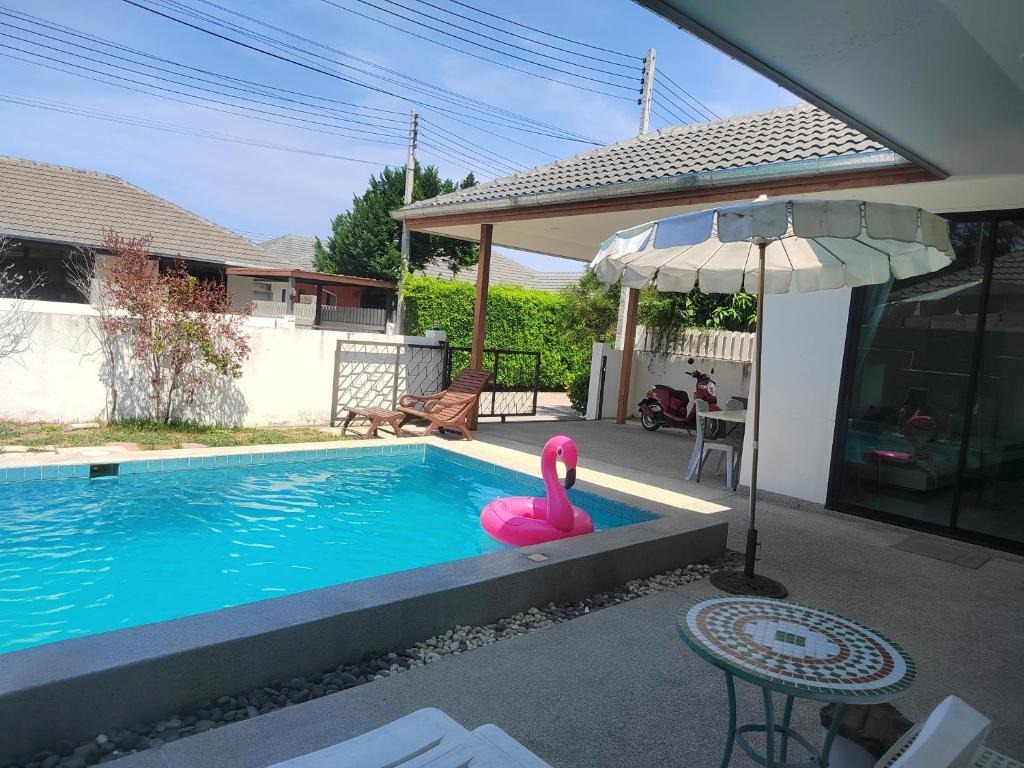 a swimming pool with a pink swan in a yard at E villa , private pool villa for your family in Hua Hin