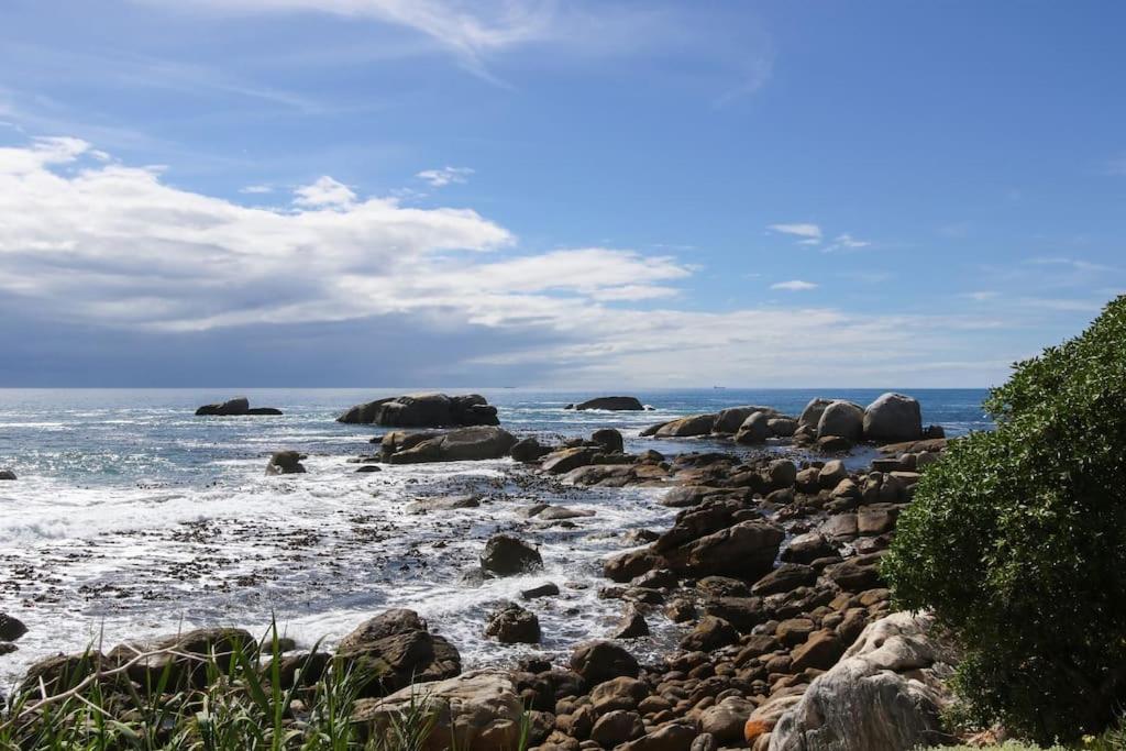 una playa rocosa con el océano y el agua en Bakoven Beach House en Ciudad del Cabo