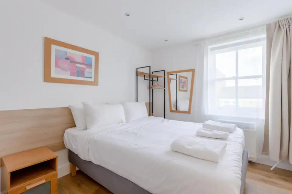 uma cama branca num quarto com uma janela em Contemporary 1BD Flat - Camden em Londres