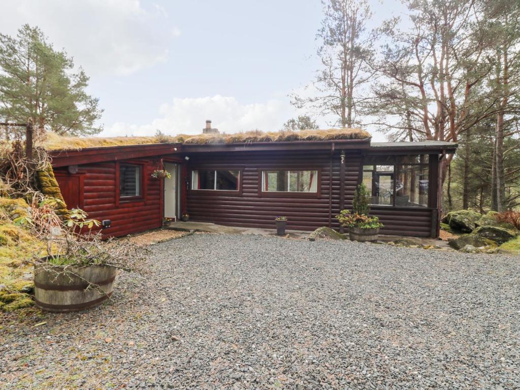 a log cabin with a gravel driveway in front of it at Rocksite in Blairgowrie