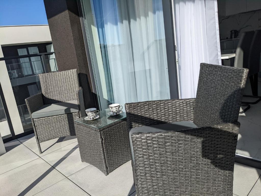 three chairs and a table on a balcony at LUXURY AQUA APARTMENTS przy AQUAPARK REDA in Rumia