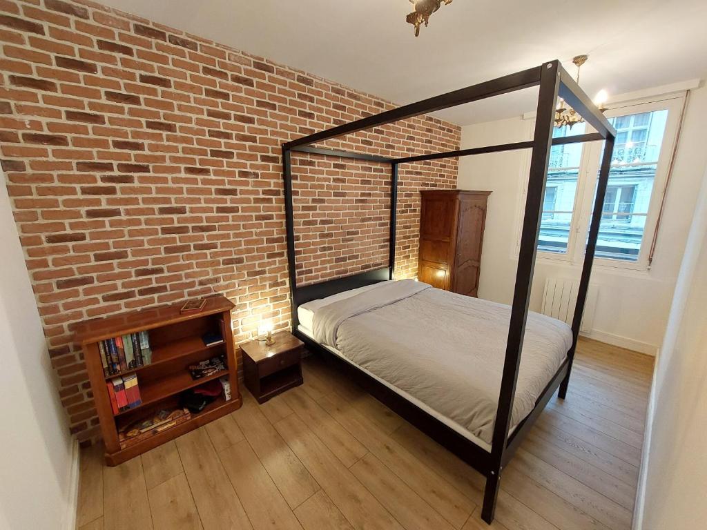 sypialnia z łóżkiem przy ceglanej ścianie w obiekcie La Chambre des Sorciers w mieście Blois