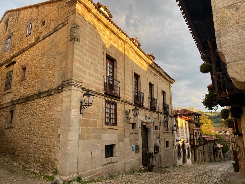 an old stone building with windows on a street at Hotel Altamira in Santillana del Mar