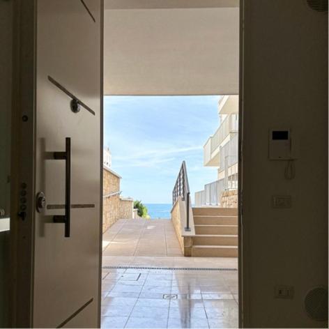 une porte menant à un couloir avec vue sur un bâtiment dans l'établissement SUITE CALA PAURA, à Polignano a Mare