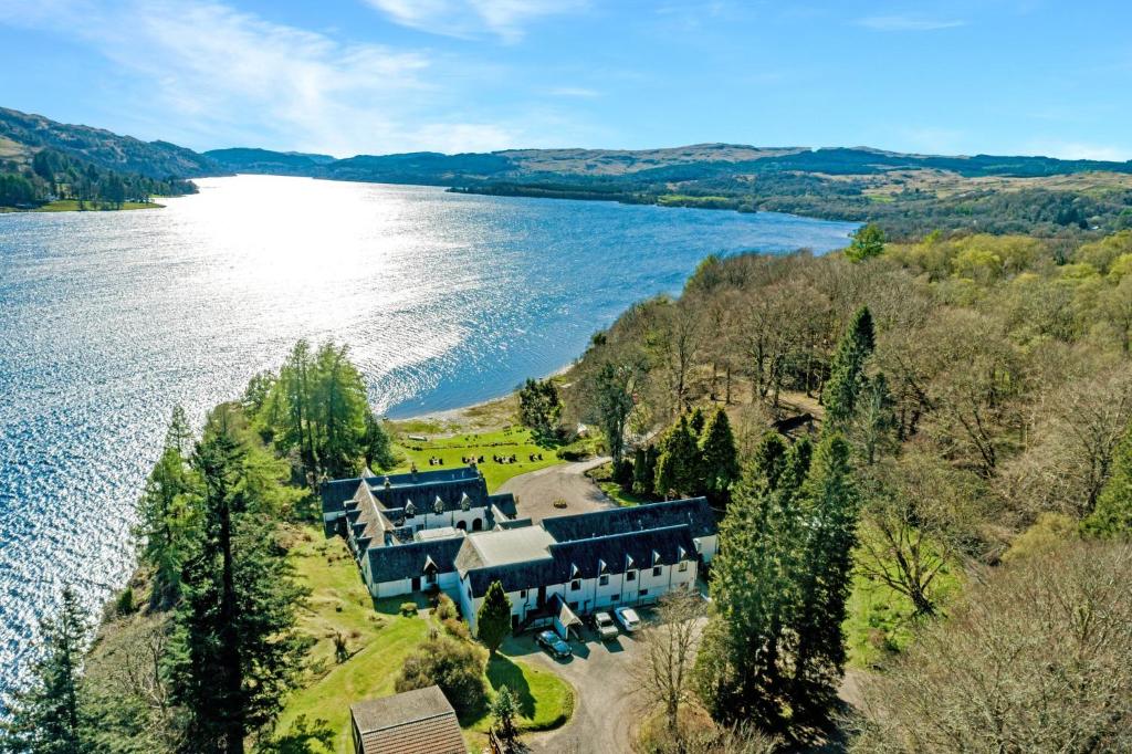 an aerial view of a house next to a lake at Taychreggan Hotel in Kilchrenan
