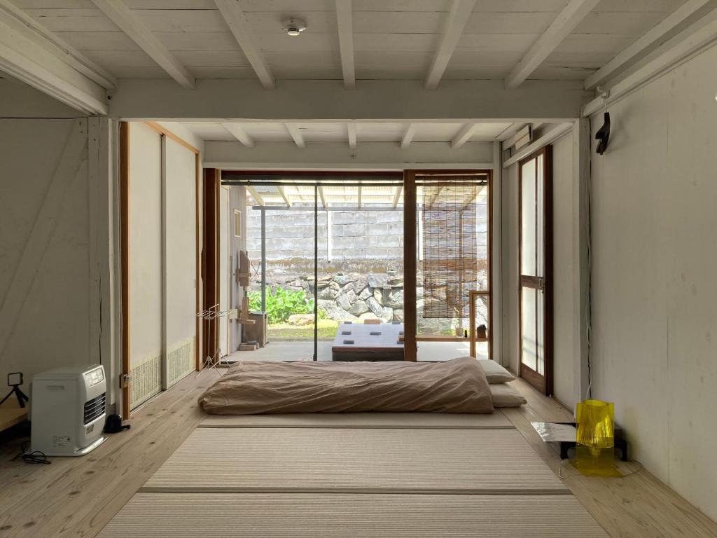 sypialnia z łóżkiem i dużym oknem w obiekcie パライソ梅田 w mieście Ise