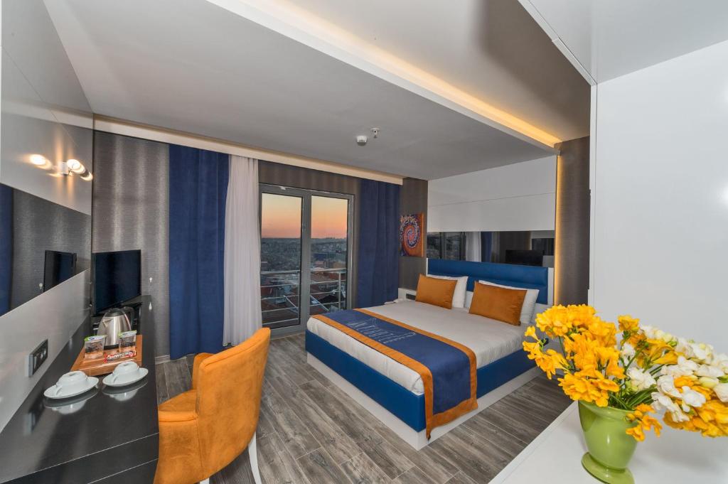 イスタンブールにあるインテル ホテル イスタンブールのベッド1台、デスク(花付)が備わる客室です。