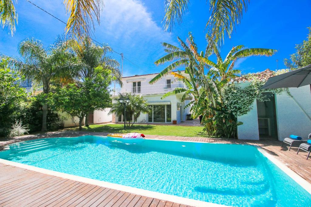 a swimming pool in front of a house at Las Rotas KD in Denia
