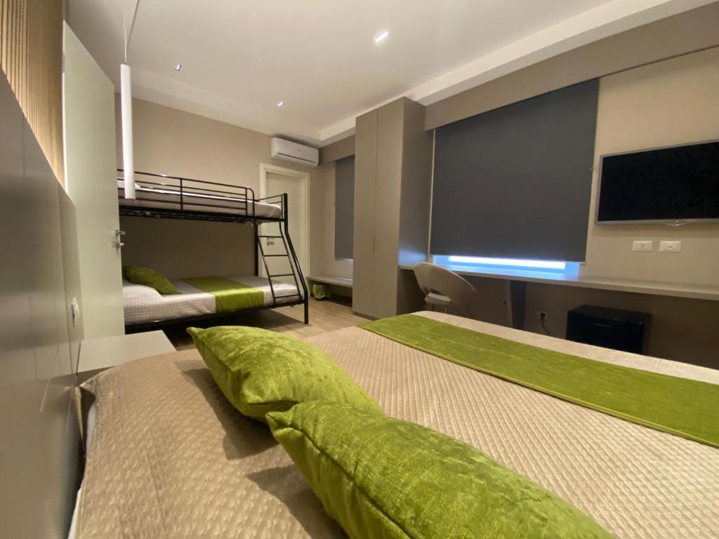 a bedroom with two bunk beds and a flat screen tv at Th Luxury Central in Catania