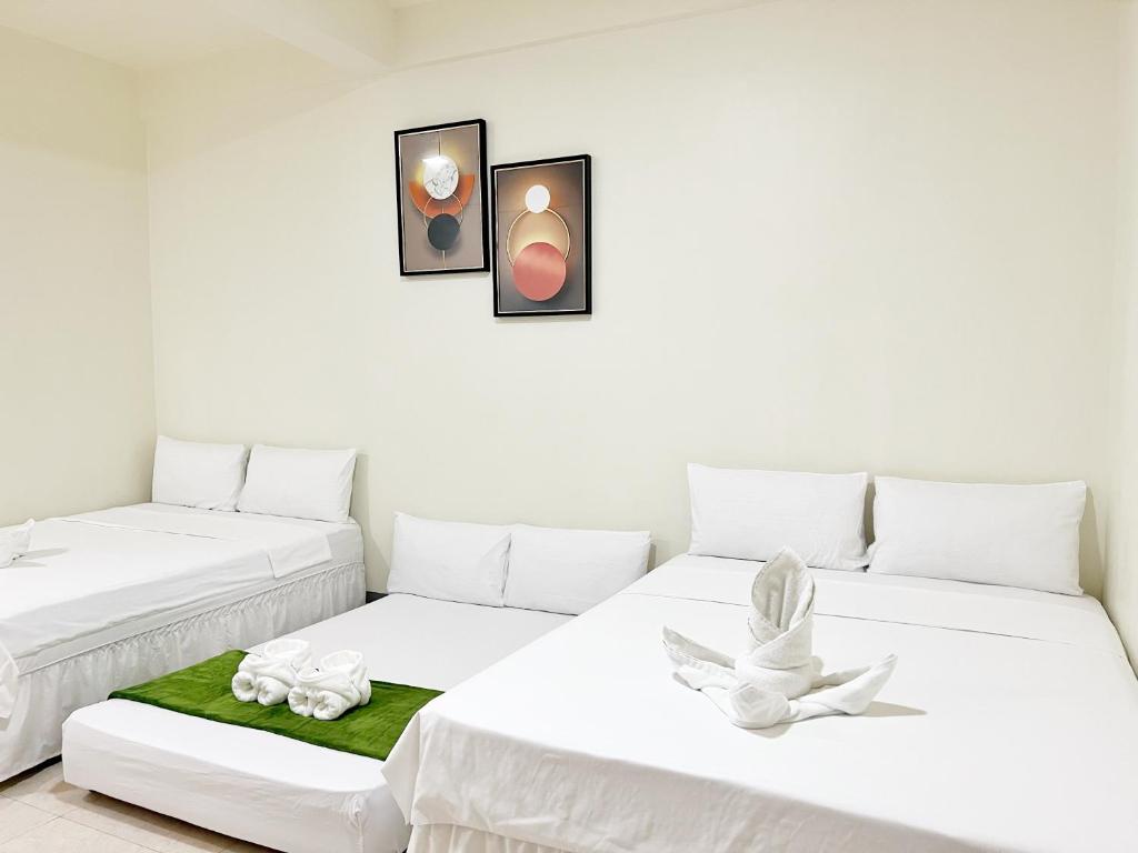 Duas camas num quarto com paredes brancas em Verra Inn em Tagaytay