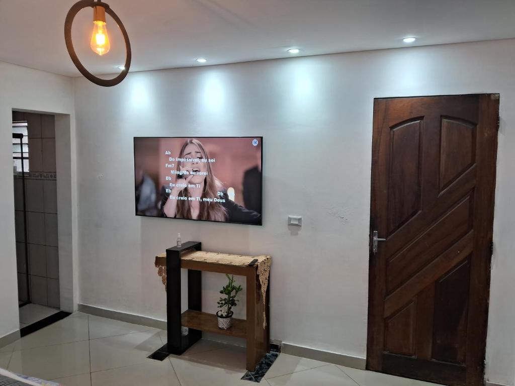 a television on a wall next to a door at Kitnet Suite próxima aeroportoe Guarulhos in Guarulhos
