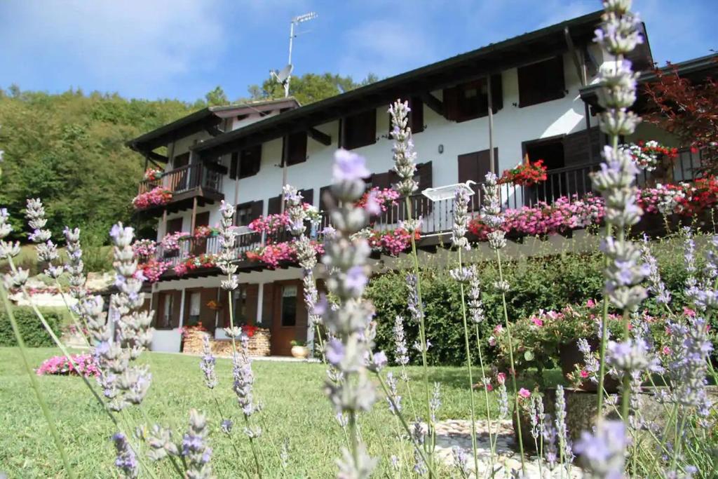 un bâtiment avec des fleurs devant lui dans l'établissement The Duck's Cottage, à Feltre