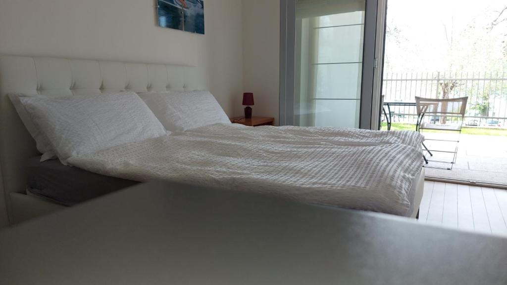 Bett in einem Schlafzimmer mit Blick auf einen Balkon in der Unterkunft Villa Treccani Apartments in Malcesine