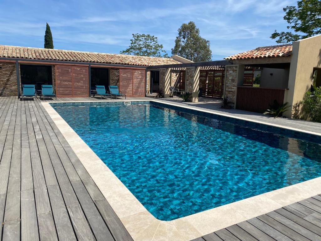 una piscina de agua azul en un patio en Magnifique villa avec piscine au coeur des vignes en Cogolin