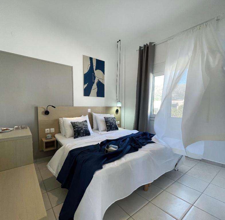a bedroom with two beds and a window at Vista Mare in Koutsourás