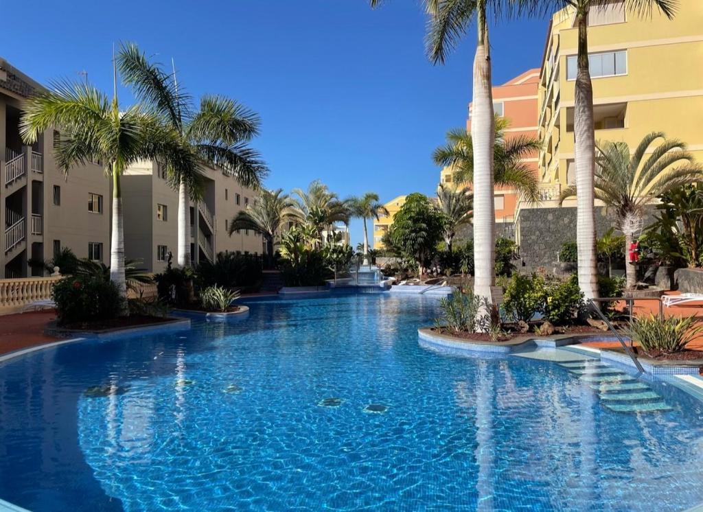 una gran piscina con palmeras en un complejo en Laderas del Palmar Luxury en El Palmar