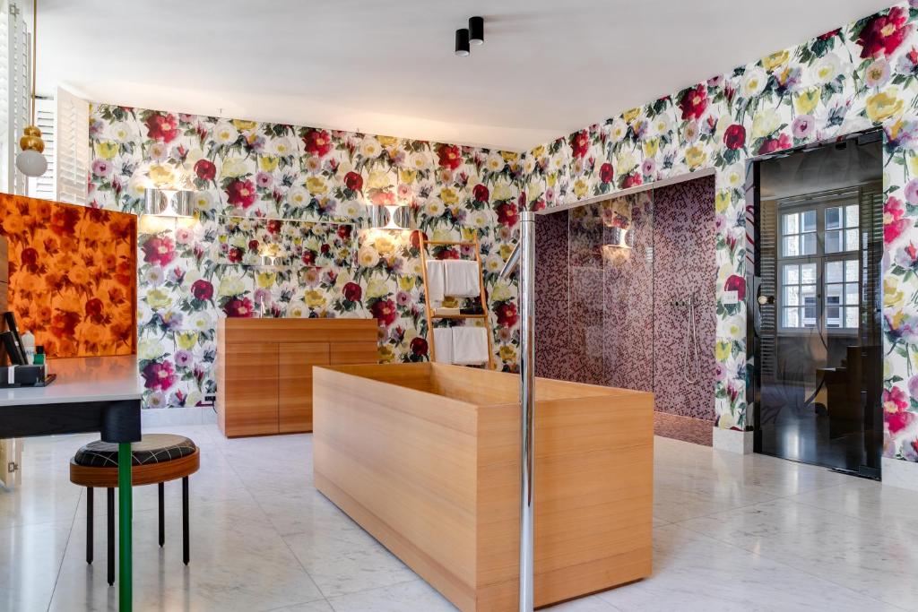 um quarto com papel de parede floral nas paredes em Small Luxury Hotel De Witte Lelie em Antuérpia