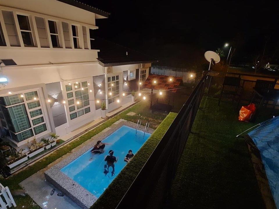 duas pessoas a brincar numa piscina à noite em ADRIANA CABIN em Malaca
