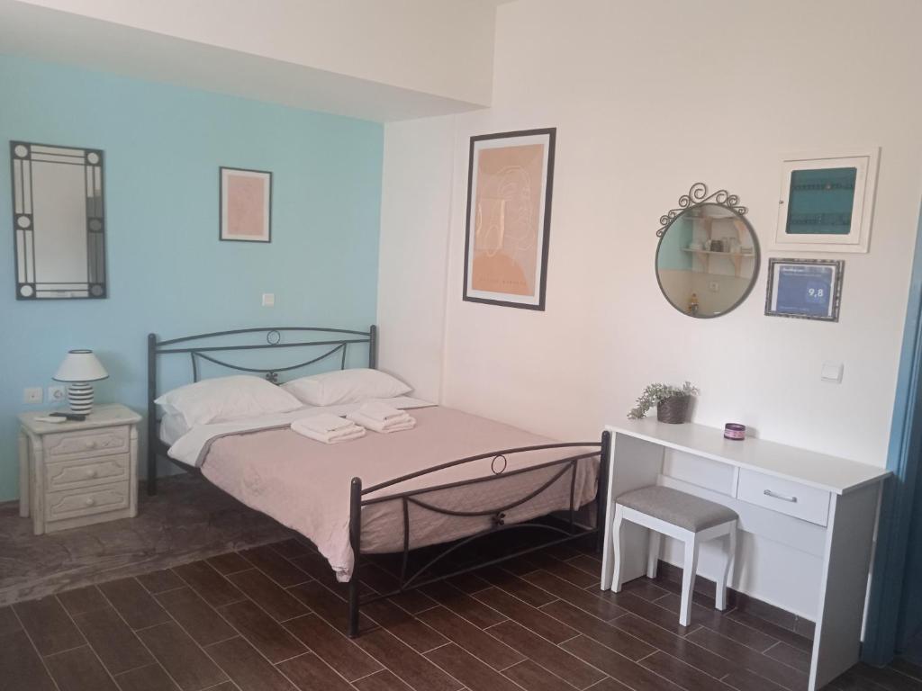 um quarto com uma cama, uma secretária e um espelho. em Ag.apostoloi studios em Áyioi Apóstoloi