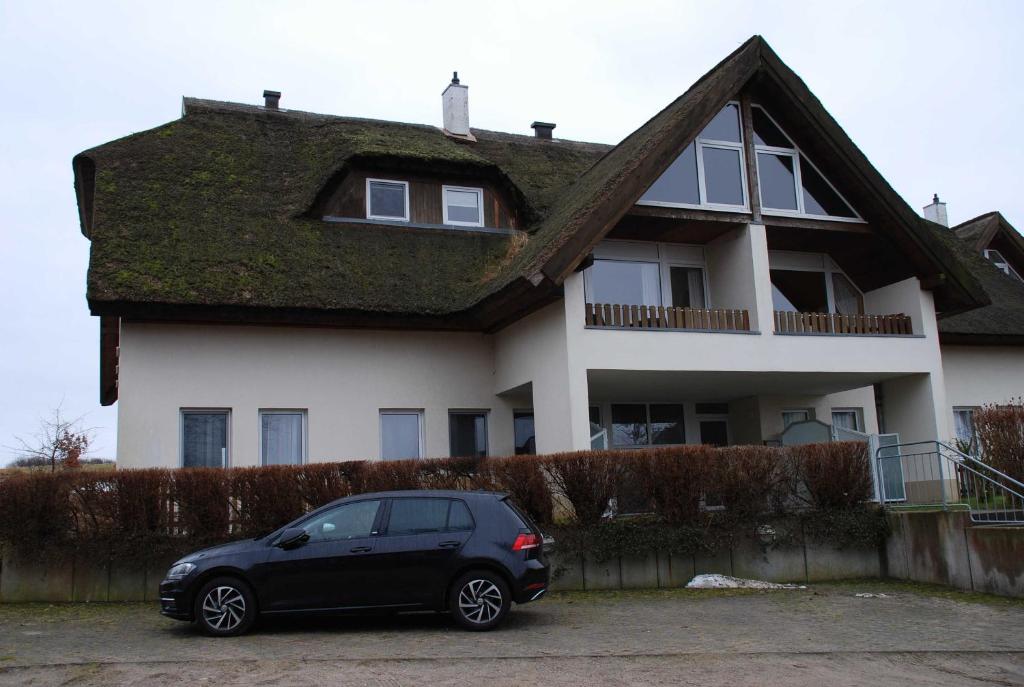 ein schwarzes Auto, das vor einem Haus geparkt ist in der Unterkunft Strandhaus Lobbe - Fewo 45499 in Lobbe