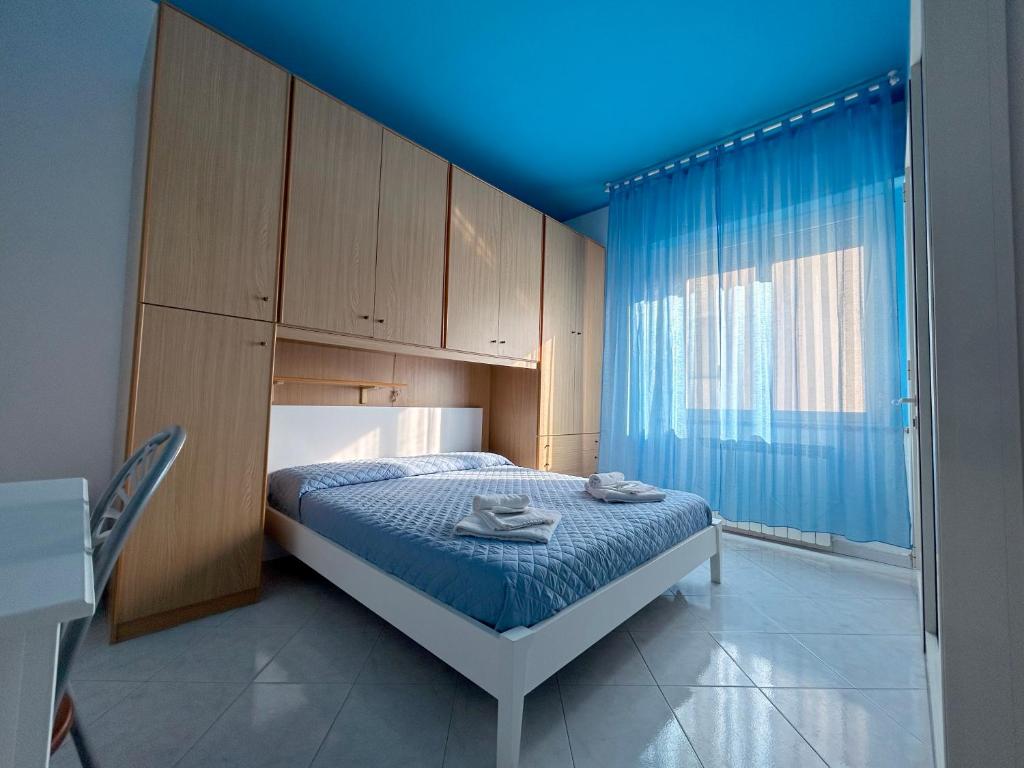 1 dormitorio con 1 cama con techo azul en Affittacamere I Gigli di Mare, en Marina di Bibbona