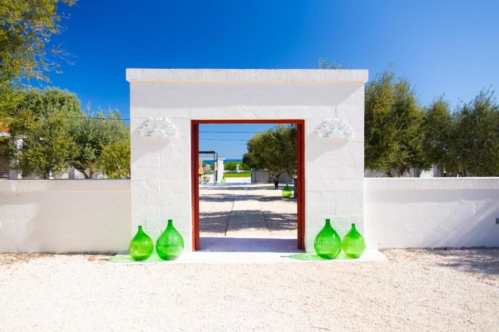 un grupo de jarrones verdes sentados frente a una puerta en Tenuta Amostuni-Country House en Ostuni