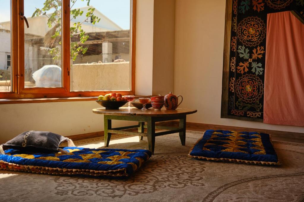 a room with a table and two pillows on the floor at Guest House Altyn Oimok in Bokonbayevo