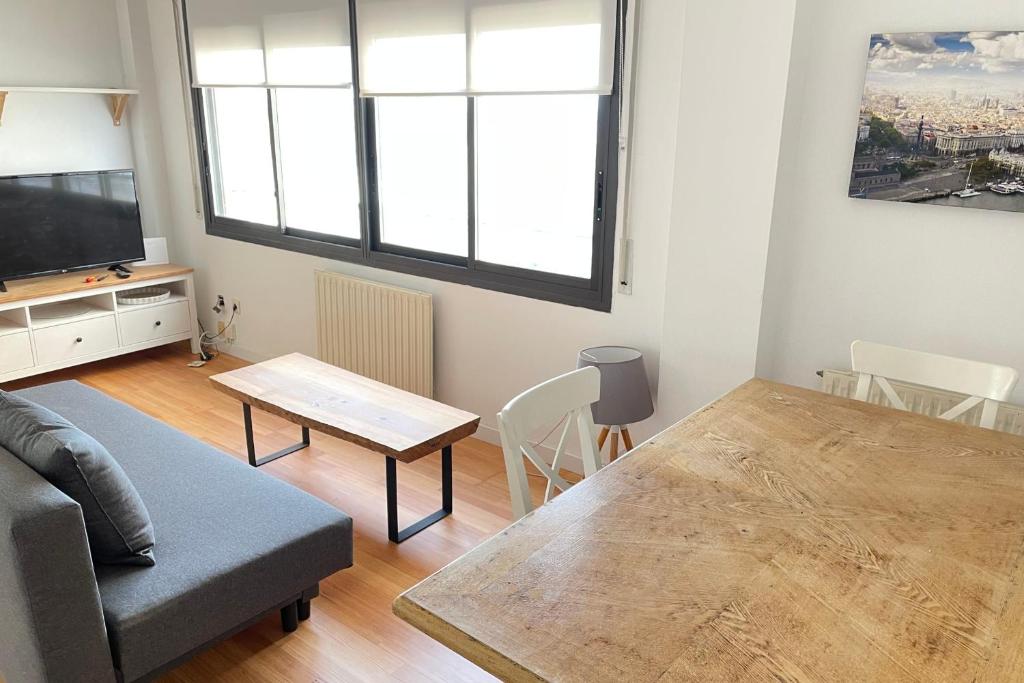 a living room with a couch and a table at Apartment with sea views next to the beach of Mar Bella in Barcelona