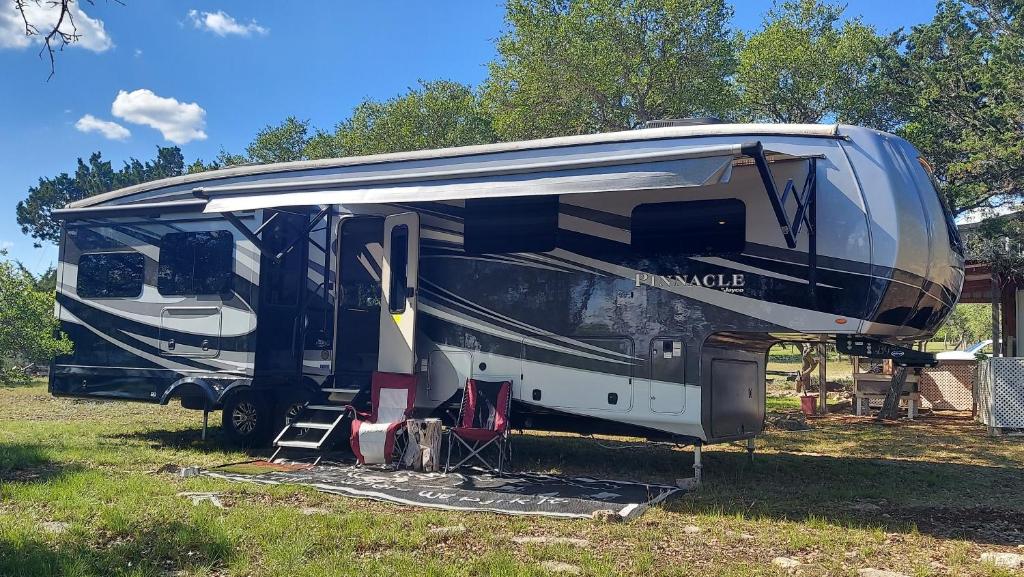 una caravana estacionada en un campo con la puerta abierta en Hill Country Luxury RV Glamp: Twin Falls, Texas en Boerne