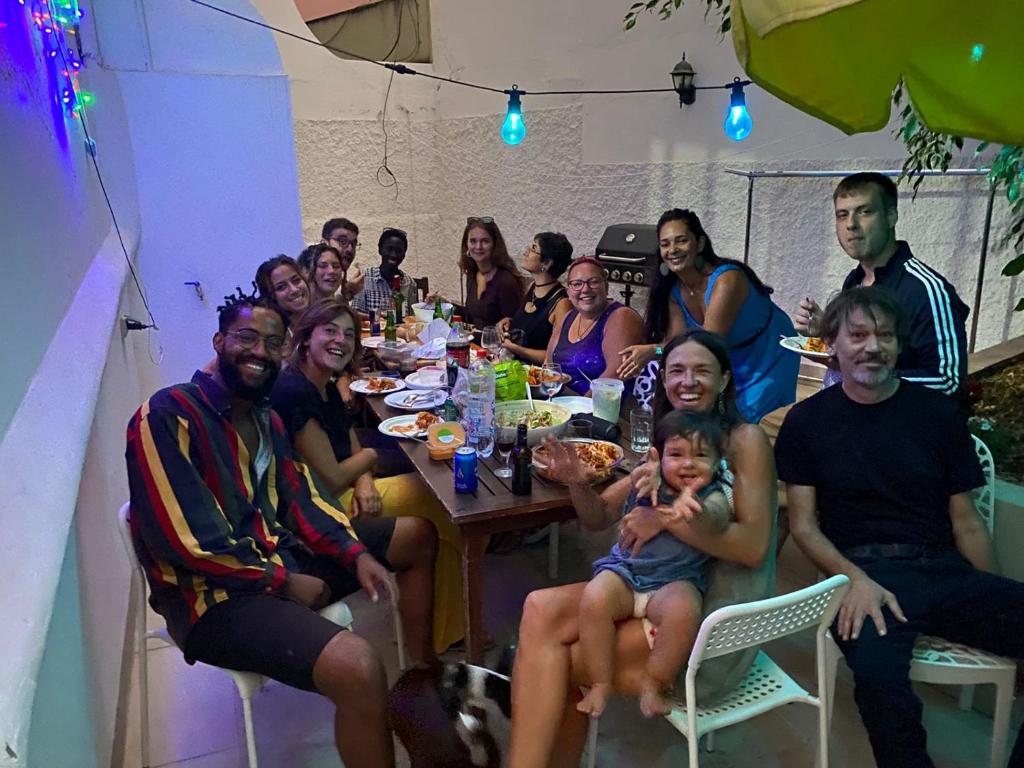 un grupo de personas sentadas alrededor de una mesa comiendo en Nomad Villa Santa Fe en Las Palmas de Gran Canaria