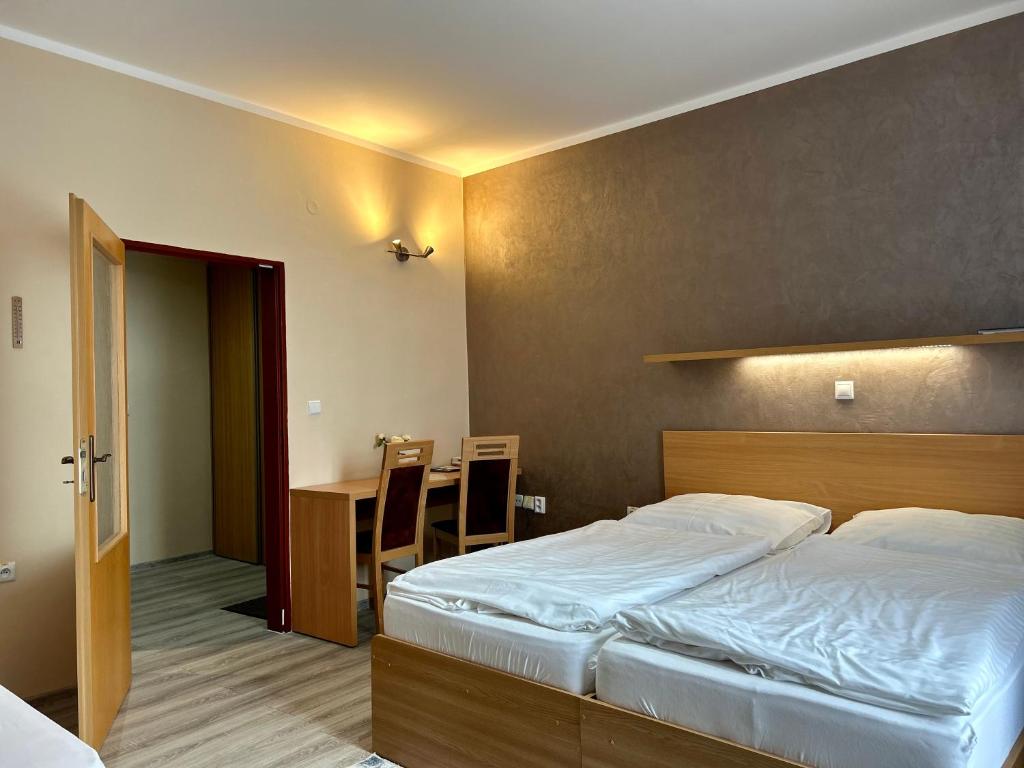 A bed or beds in a room at Hotel Roháč