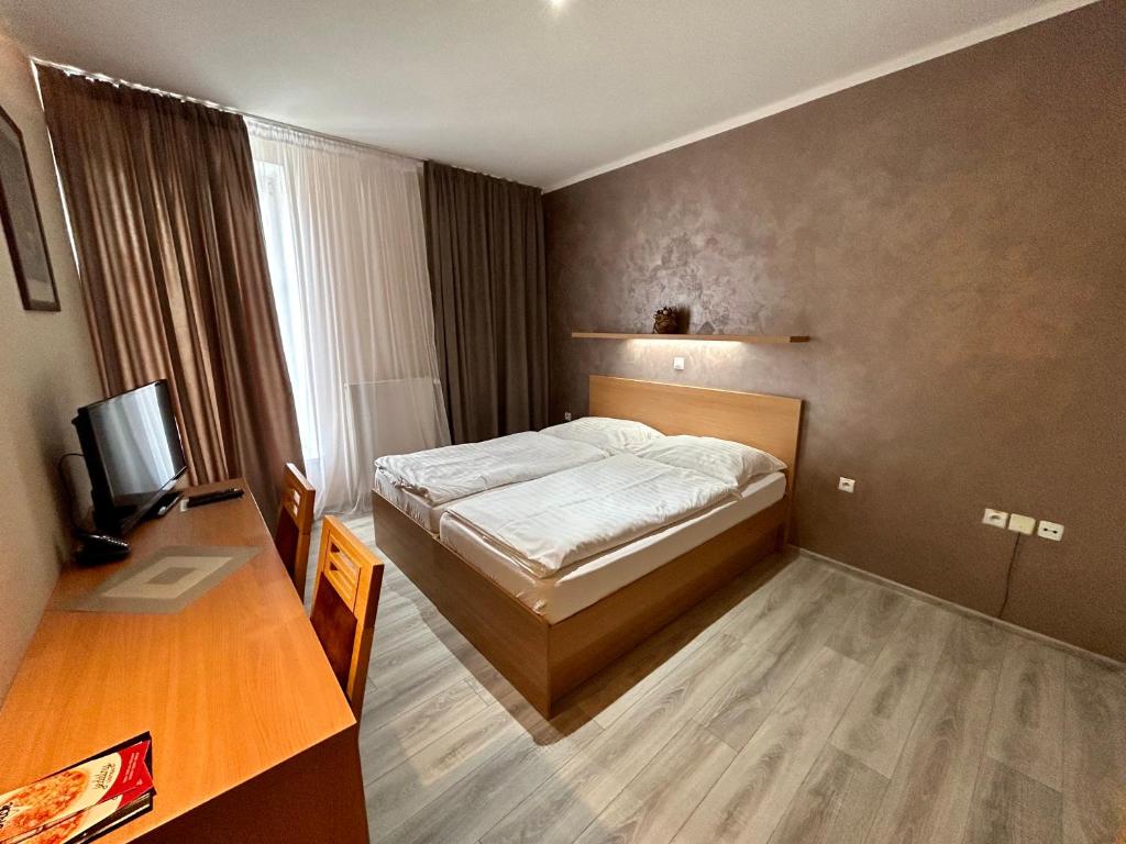 A bed or beds in a room at Hotel Roháč