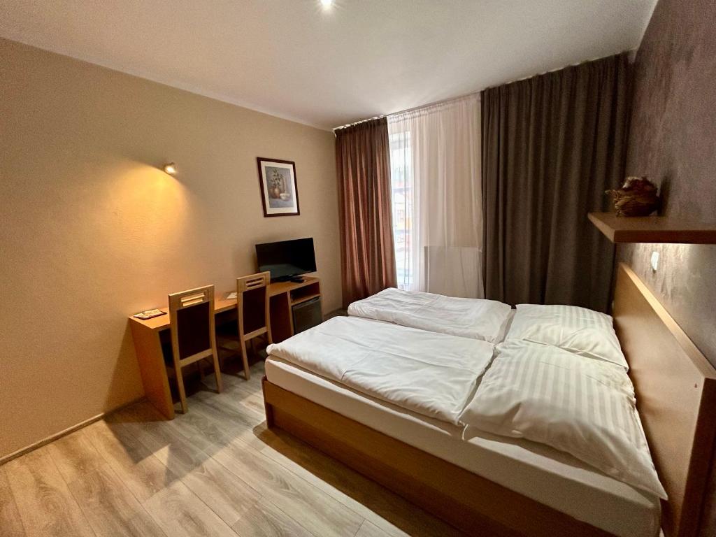A bed or beds in a room at Hotel Roháč