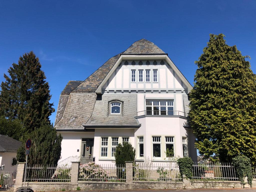 una casa blanca con techo de gambrel en Villa Rosa - Garden, en Detmold