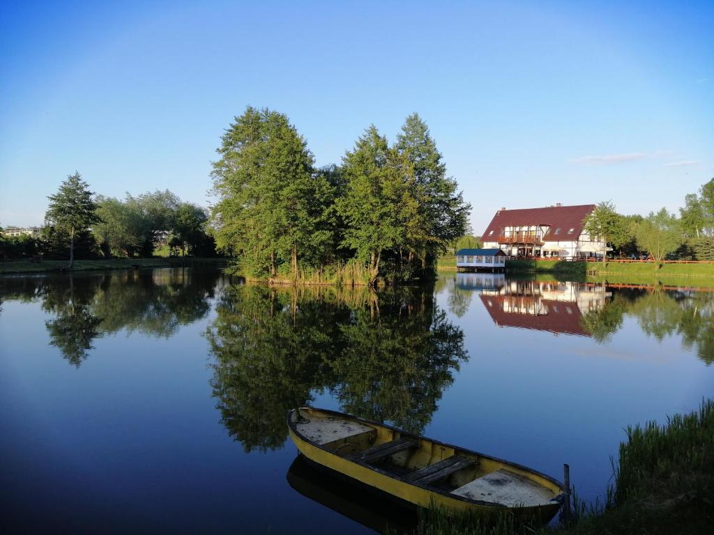 a boat sitting on the water next to a house at U Górala in Cieszków