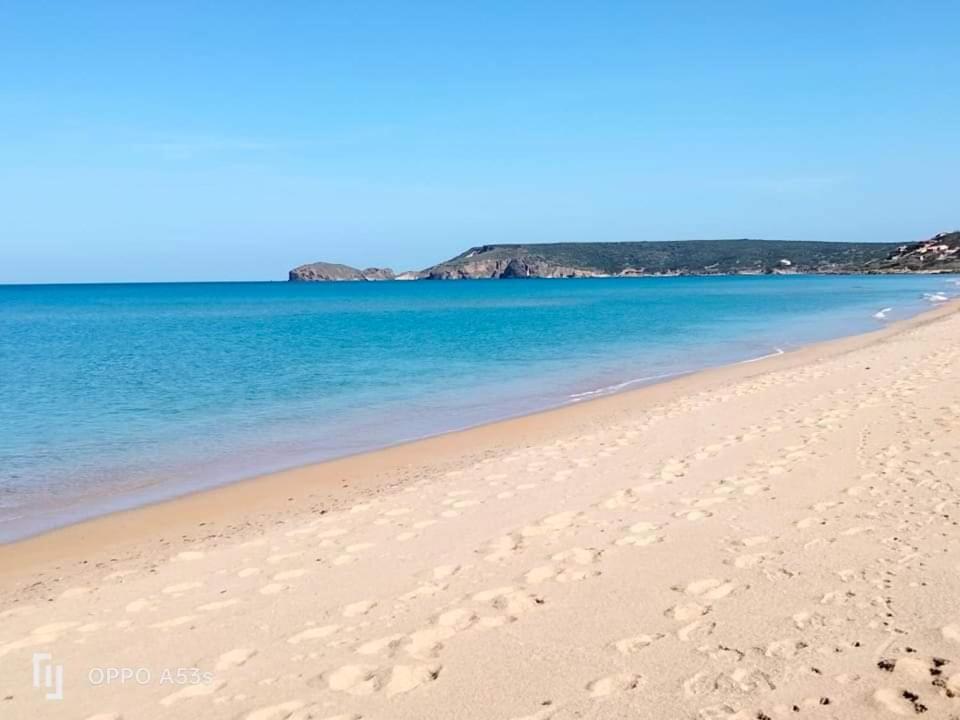a beach with blue water and footprints in the sand at La casa di Mo' in Torre Dei Corsari