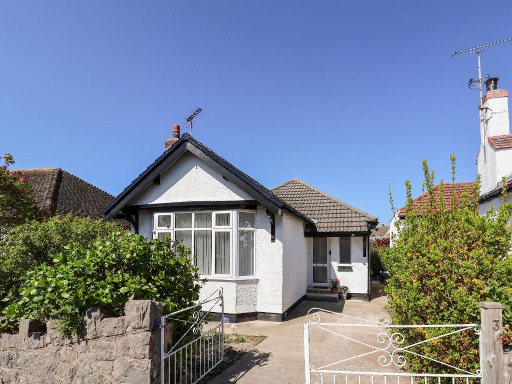 a white house with a black roof at 3 Rhyd Drive in Colwyn Bay