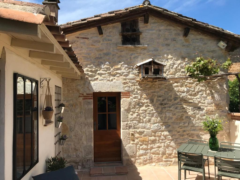 a stone house with a table in front of it at Le pigeonnier du beffroi in Bruniquel