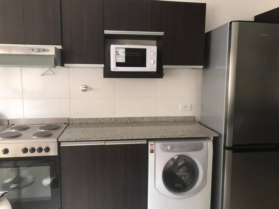 een keuken met een wasmachine en een magnetron bij Departamento Beltrán in Godoy Cruz