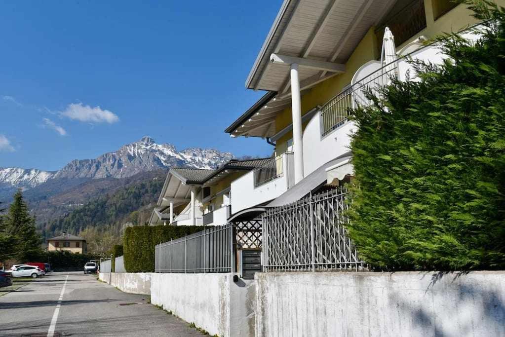 a house on a street with mountains in the background at A Caldonazzo cé proprio tutto in Caldonazzo