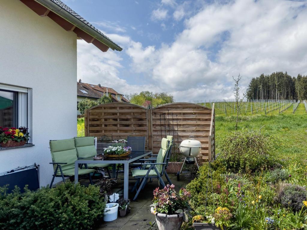 un patio con mesa, sillas y una valla en Haus Barbara, Ferienwohnung, 90qm, en Unterreitnau