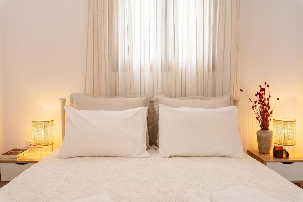 a white bed with white pillows in a bedroom at Orkos Naxian Wave 3 in Mikri Vigla