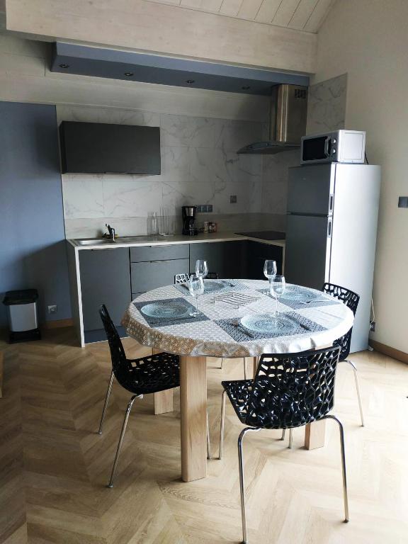 une cuisine avec une table, des chaises et un réfrigérateur dans l'établissement Studio Léopold,proche Europa Park et rulantica, à Diebolsheim
