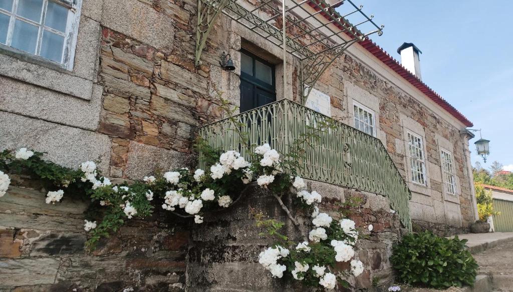 um edifício com flores ao lado em Casa do Hospital-Guest House em Abaças