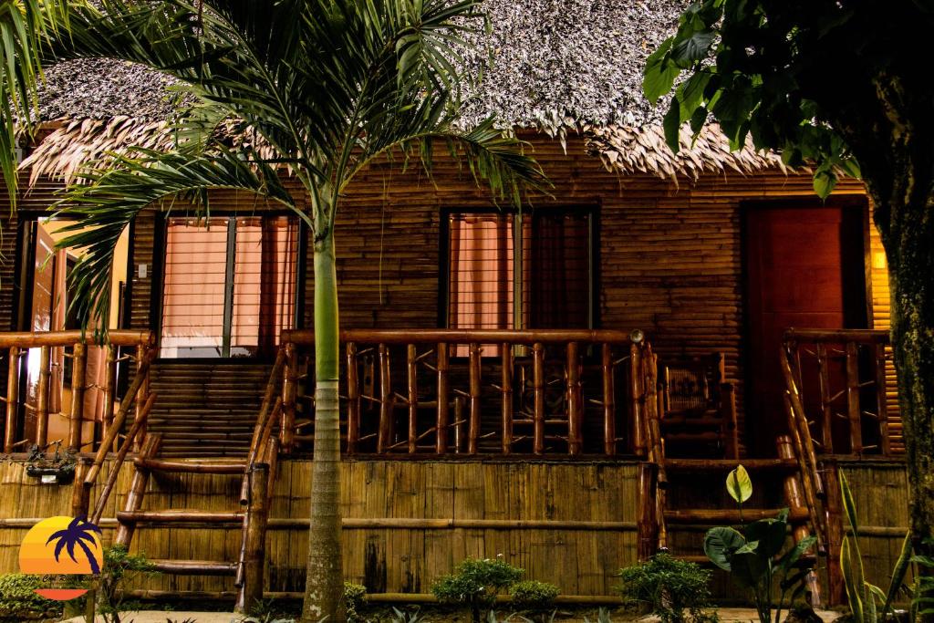 a house with a palm tree in front of it at Loboc Cool River Resort in Loboc