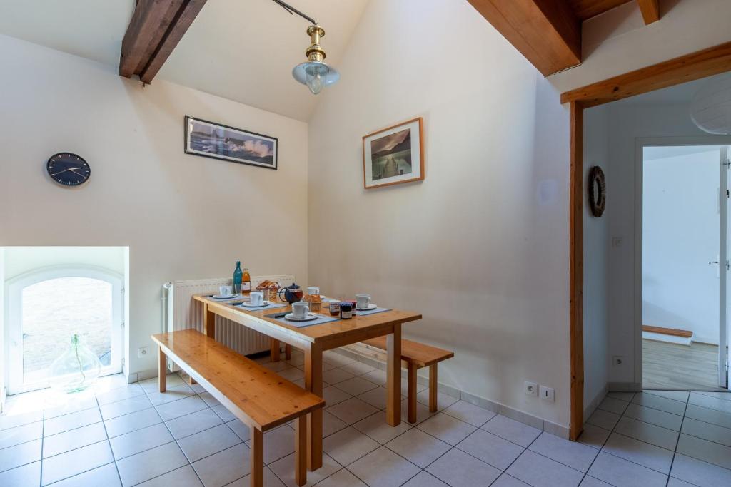 jadalnia z drewnianym stołem i ławką w obiekcie La Grange - Charmante maison à Langrune-sur-mer w mieście Langrune-sur-Mer
