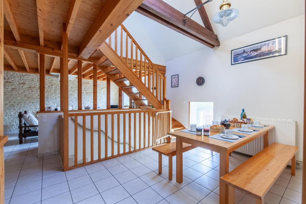 jadalnia ze stołem i schodami w obiekcie La Grange - Charmante maison à Langrune-sur-mer w mieście Langrune-sur-Mer