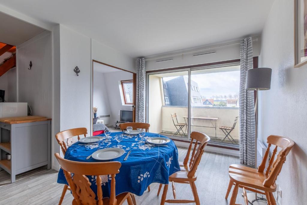 une salle à manger avec une table bleue et des chaises dans l'établissement Duplex Croisette - Duplex à Bernières-sur-Mer, à Bernières-sur-Mer